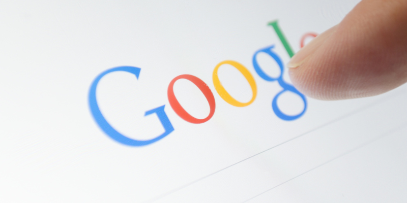 Finger pressing Google on screen